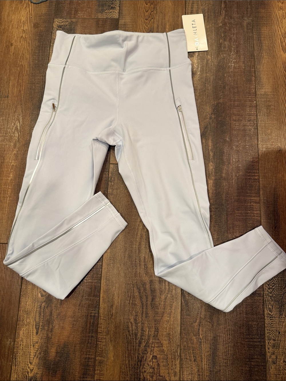 Athleta Rainier Reflective Stripe Tight Leggings with zippered pockets.